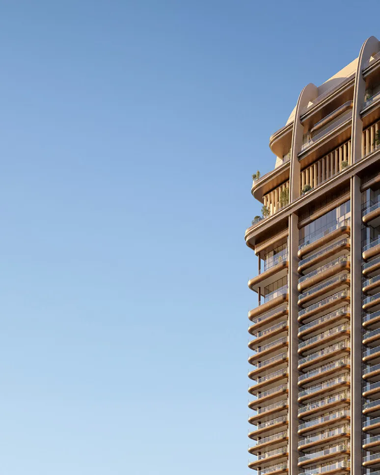 Tower's curved crown and balconies against a clear evening sky